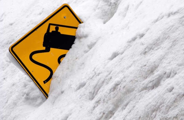 Slippery Road Sign half buried in snow