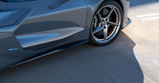 Close up view of body colored side panels and aluminum wheel in a Pearl Nickel finish on the 2024 Chevrolet Corvette E-Ray 3LZ coupe in Seawolf Gray. Pre-production model shown. Actual production model may vary. Model year 2024 Corvette E-Ray available 2023.